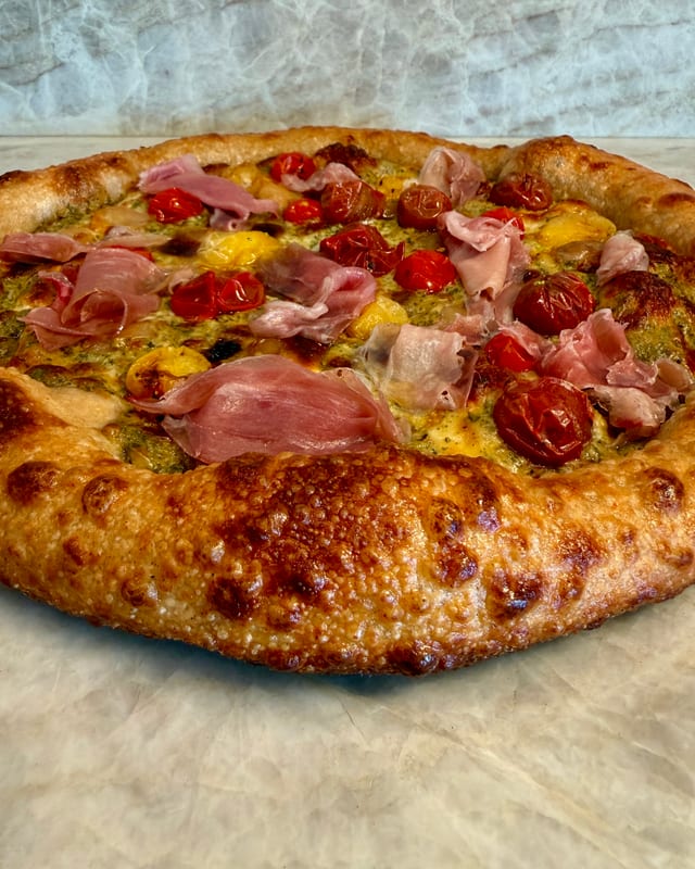 Pizza with prosciutto and tomatoes